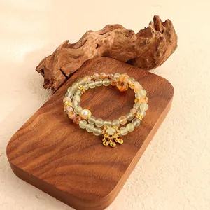 Detailed view of natural green fluorite and yellow crystal double-strand bracelet with golden lock