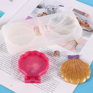Close-up view of a shell-shaped silicone mold with finished resin makeup mirrors