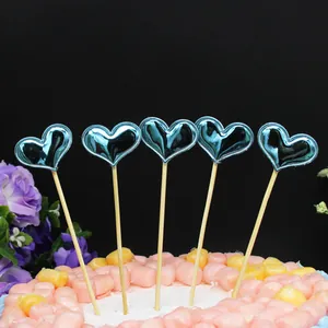 Detalle de cinco adornos para tarta con forma de corazón azul metálico sobre un pastel.