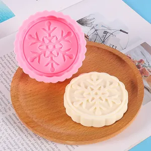 Detail showing snowflake patterned silicone mold and a finished white wax melt mold