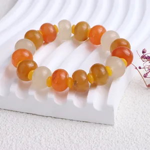 Nahaufnahme eines Perlenarmbands aus natürlicher Goldseidenjade auf weißem Stand