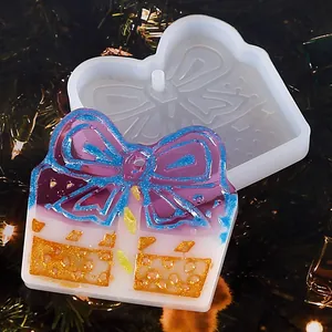 Detail showing the silicone gift box mold and a colorful finished resin pendant.