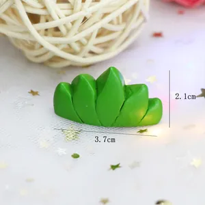 Vue détaillée d'un ornement d'herbe en résine verte, dimensions 3,7 cm x 2,1 cm