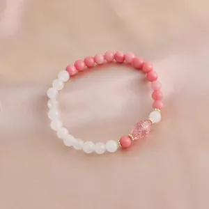 Elegantes Armband aus Naturkristallperlen mit rosa und weißen Steinen auf Seide.