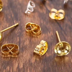 Vue détaillée des fermoirs papillon dorés et argentés pour boucles d'oreilles artisanales.