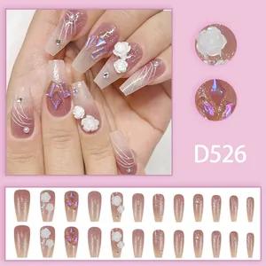 Close-up detail of pink gradient press-on nails featuring 3D roses and iridescent gems