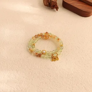 Detailed macro view of natural green fluorite and yellow crystal beads with golden lock charm