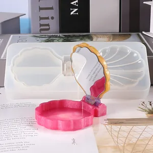Macro view of shell-shaped silicone mold and finished resin compact mirror set