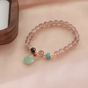 Detailed view of natural strawberry quartz bracelet with a delicate green jade pendant