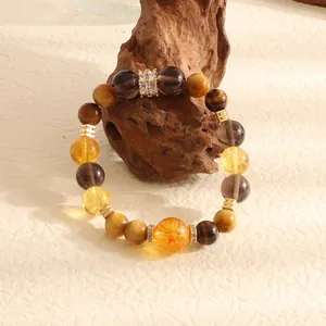 Macro detail of natural citrine and tiger eye beaded bracelet on rustic wood stand