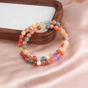 Detail of double-layer beaded gemstone bracelet with amethyst on pink satin background