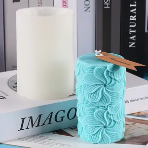 Vue détaillée du moule en silicone cylindrique et de la bougie fleurie bleue finie.