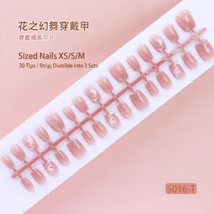 Macro detail of 30pcs nude pink press-on nails with white flowers and silver glitter.
