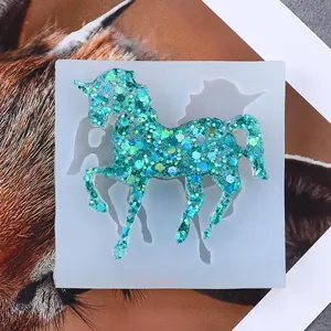 Detailed view of blue glitter resin unicorn in a square translucent silicone craft mold