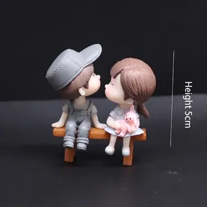 Hand-painted cute kissing couple figurines sitting on a bench for wedding gift and cake topper