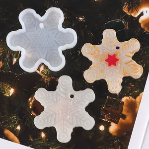 Snowflake silicone mold and resin crafts displayed against a festive Christmas tree.