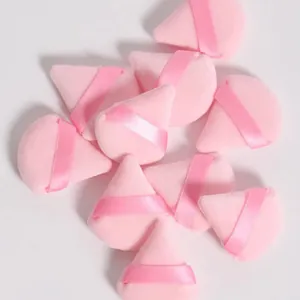 Gedetailleerd macrozicht van zachte roze driehoekige make-uppuffs voor poeder.