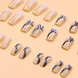 Close-up of nude French press-on nails featuring elegant black ribbon and glitter accents.