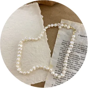 Vintage baroque natural pearl necklace with gold clasp on aesthetic vintage background