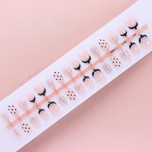 Detailed view of elegant French tip and black polka dot press-on nails with silver glitter