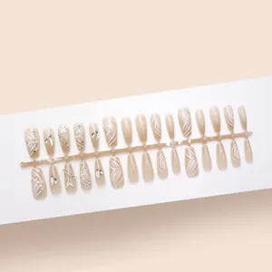 Detailansicht der nudefarbenen Press-on-Nägel mit Schmetterlings- und Glitzerakzenten