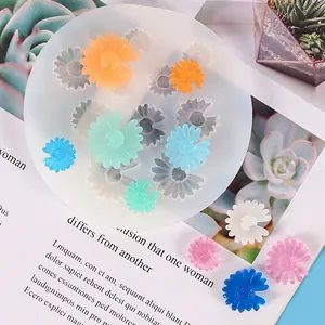Detailed view of daisy silicone mold with colorful flower resin samples on a magazine.