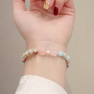 Detailed view of handmade natural Shoushan stone bracelet with heart-shaped pink quartz.