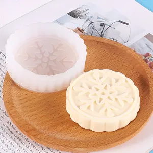 Detail view of silicone mold and finished snowflake-patterned soap on wooden tray