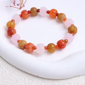 Nahaufnahme eines Natur-Goldseiden-Jade-Armbands mit mehrfarbigen Kürbisperlen