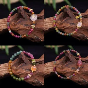 Detail view of four styles of multi-colored crystal beaded bracelets on dark wood base.