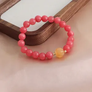 Detailansicht eines Armbands aus rotem Rhodochrosit mit einer gelben Kürbisperle