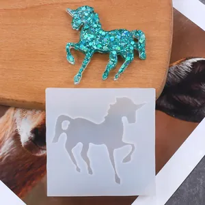Detailed view of a unicorn silicone mold with a glittery teal resin finished unicorn piece