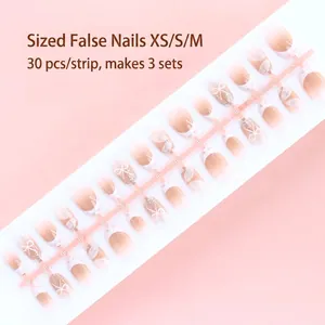 Detail view of French style press-on nails with bow and pearl accents, 30pcs sized set.