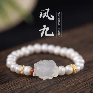 Close-up of a freshwater pearl bracelet with a carved white jade-like floral center