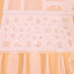 Close-up view of various multi-shape silicone resin molds with pipettes for jewelry making