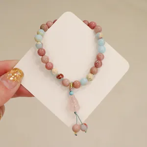 Detailed view of natural stone bracelet with pink lotus pod charm and colorful beads