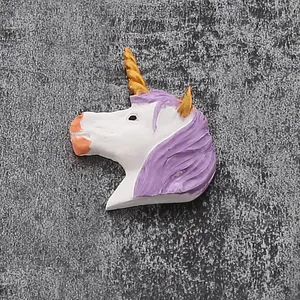 Close-up of a white unicorn decoration with purple mane and gold horn for cake topping
