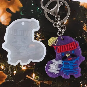 Christmas DIY silicone mold and purple resin Santa keychain on a festive background