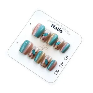 Short cat-eye press-on nails with butterfly pattern and teal-brown gradient