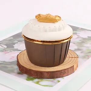 Caissettes à cupcakes en papier marron avec bordure dorée sur un socle en bois rustique.