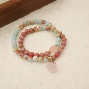 Detailed view of a handmade natural stone bracelet featuring pink crystal and blue stone beads.