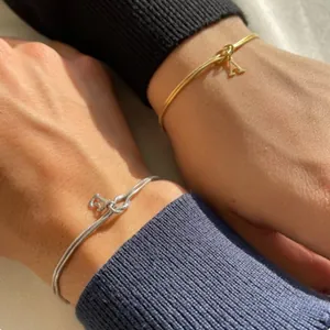 Detailed view of knot snake chain bracelets with initial letter pendants