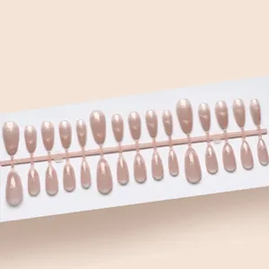 Détail des faux ongles courts œil de chat avec une finition nude scintillante