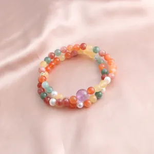 Close-up detail of a double-strand bracelet featuring vibrant multi-color gemstones and pearls