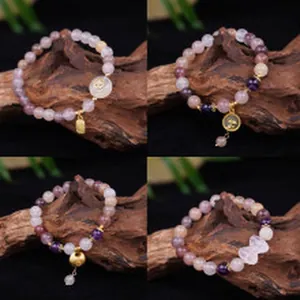 Collage of natural amethyst and quartz beaded bracelets with gold charms on wood.