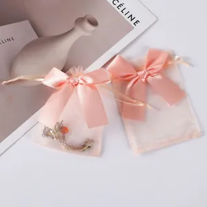 Close-up of pink organza jewelry bags with elegant satin bows and drawstring closure.