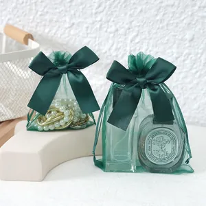 Close-up of green organza jewelry bags with satin bows showing storage capacity.