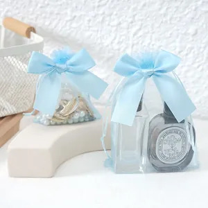 Detail view of light blue organza drawstring gift bags with elegant large satin bows.