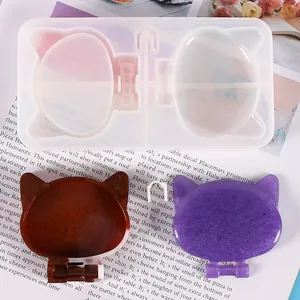 Detailed view of cat-shaped DIY silicone mold with finished brown and purple resin pieces