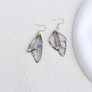 Detailed view of translucent butterfly wing earrings with iridescent rhinestones